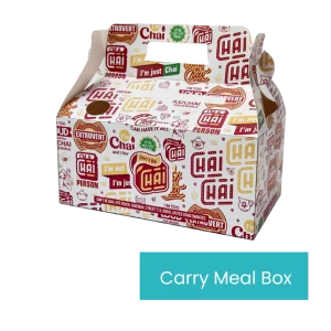 A white Carry Meal Box features a vibrant, repeating pattern with phrases like "Chai," "I'm just Chai," "Can I Chai," and "Don't Be Chai." It has a cut-out handle at the top for easy carrying and a blue label at the bottom right corner that prominently reads “Carry Meal Box.”